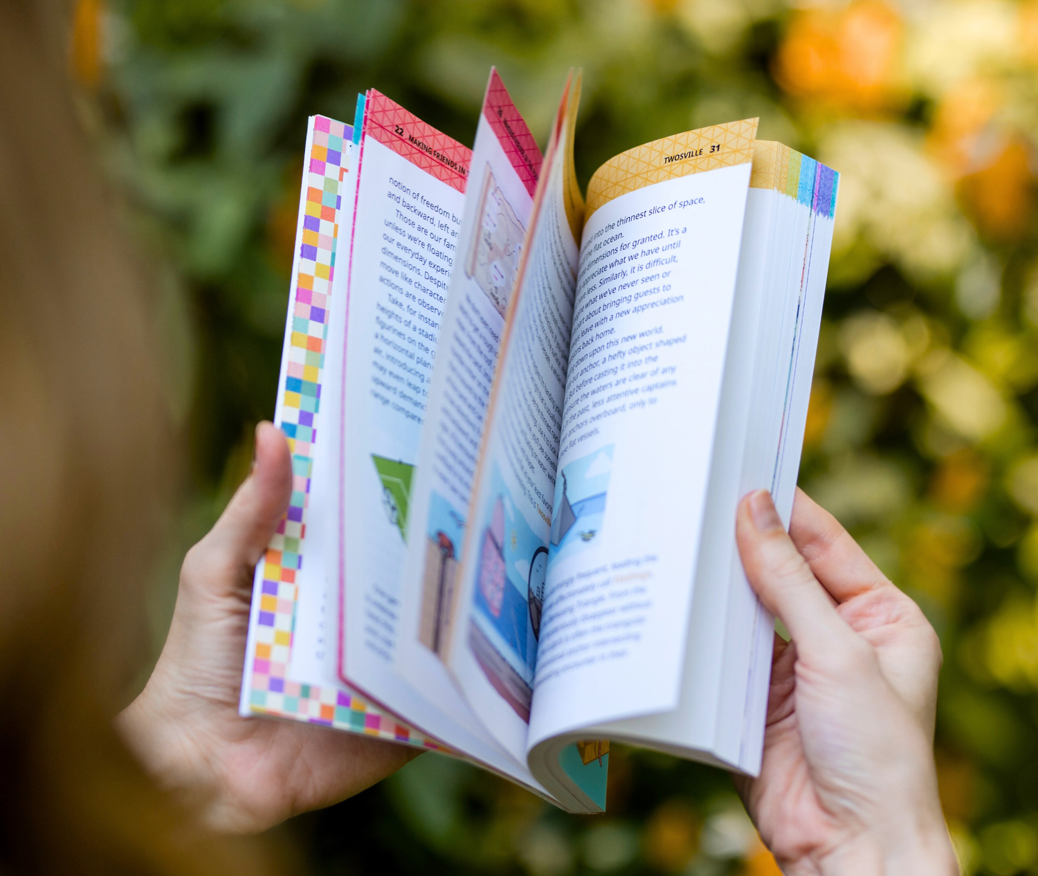 Open book held by hands with a blurred natural background